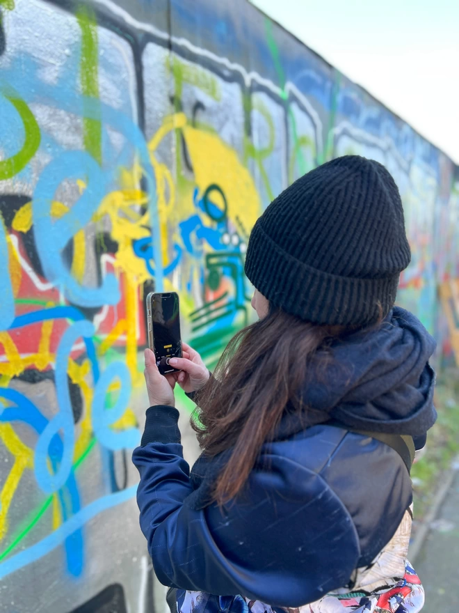 Evi Antonio artist taking photographs on her iphone around Brick lane, East London