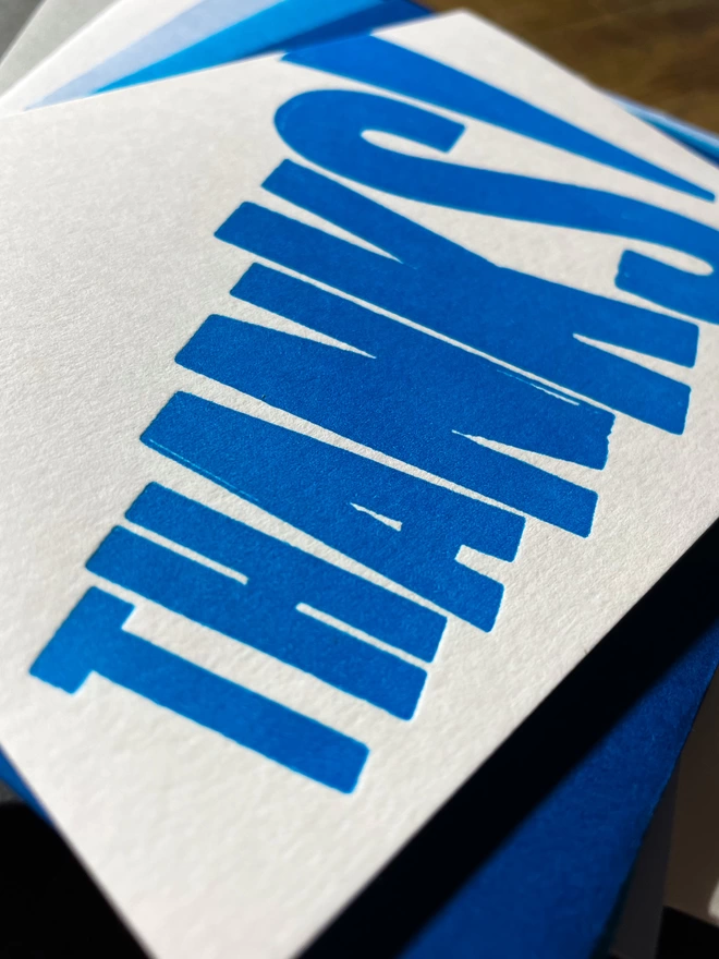 Thanks! A vibrant thank you typographic letterpress card with deep impression print using fluorescent blue, with a range of colourful envelopes. Slight print variations adding to the style anding to the charm of this handmade greeting card.