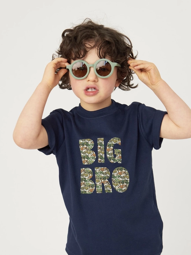 Big Bro appliquéd in a vintage cars Liberty print on a navy cotton t-shirt. Worn by a smiling 5 year old boy.