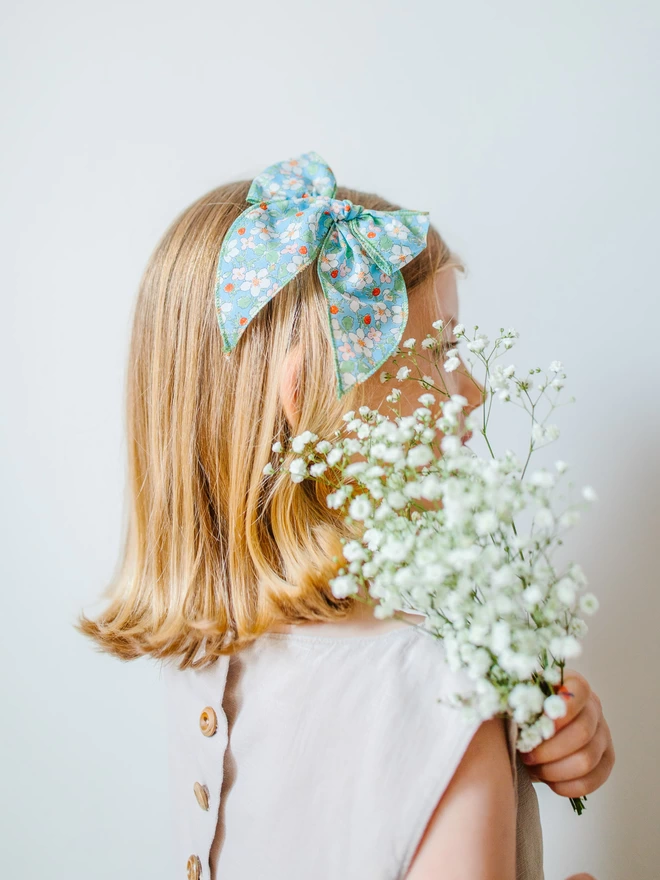 Girl with liberty blue floral bow and flowers