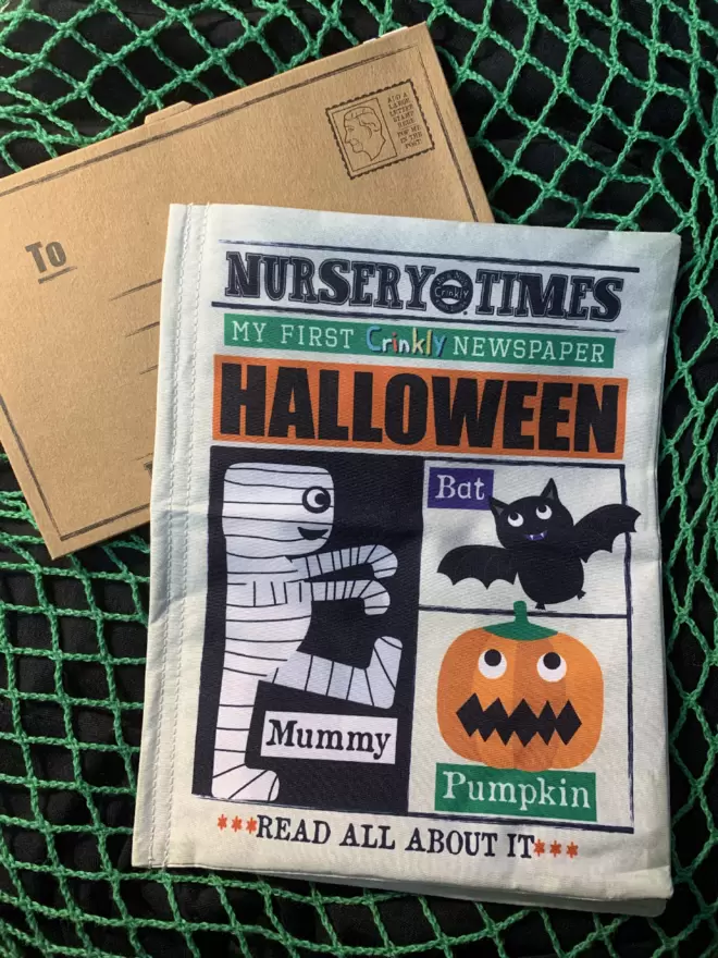 Halloween crinkly cloth newspaper front with envelope on a green and black netted background