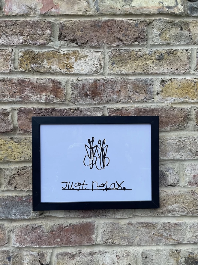 Unique handwritten black font on a white background with two black butterflies above.  The artwork is in a black frame hung on a brick wall.