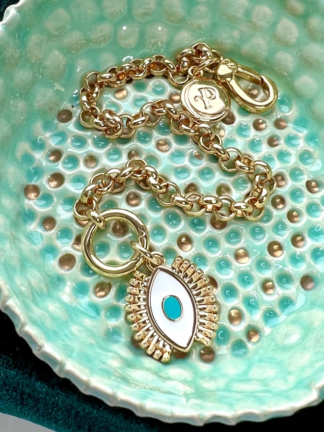 Gold belcher chain bracelet in turquoise dish with a turquoise and white evil eye charm