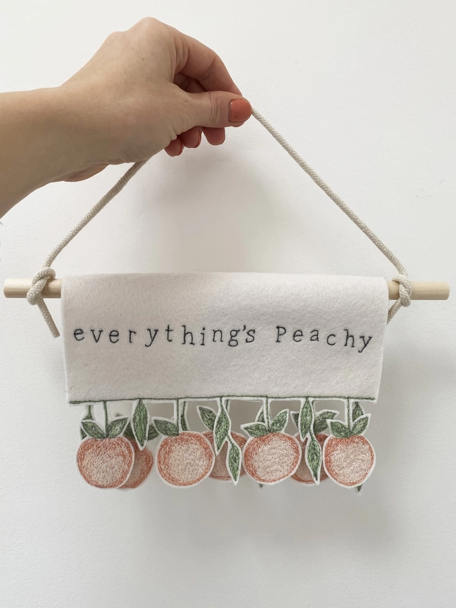 Hand holding everything's peachy banner.