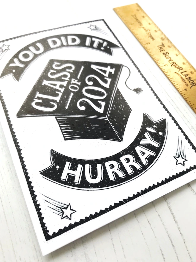 black and white class of 2024 graduation card with brass ruler