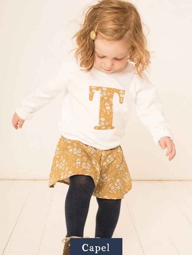 Childrens T-shirt in white with initial on the front in Capel Mustard Liberty print fabric