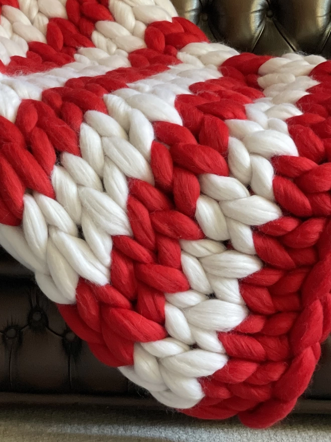 A bright red and white striped merino giant knitted blanket