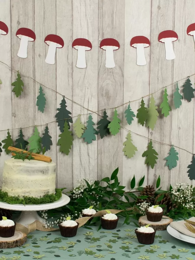 Mushroom Paper Bunting dispalyed with 2 oak leaf garlands as part of a backdrop for a woodland themed dessert table.