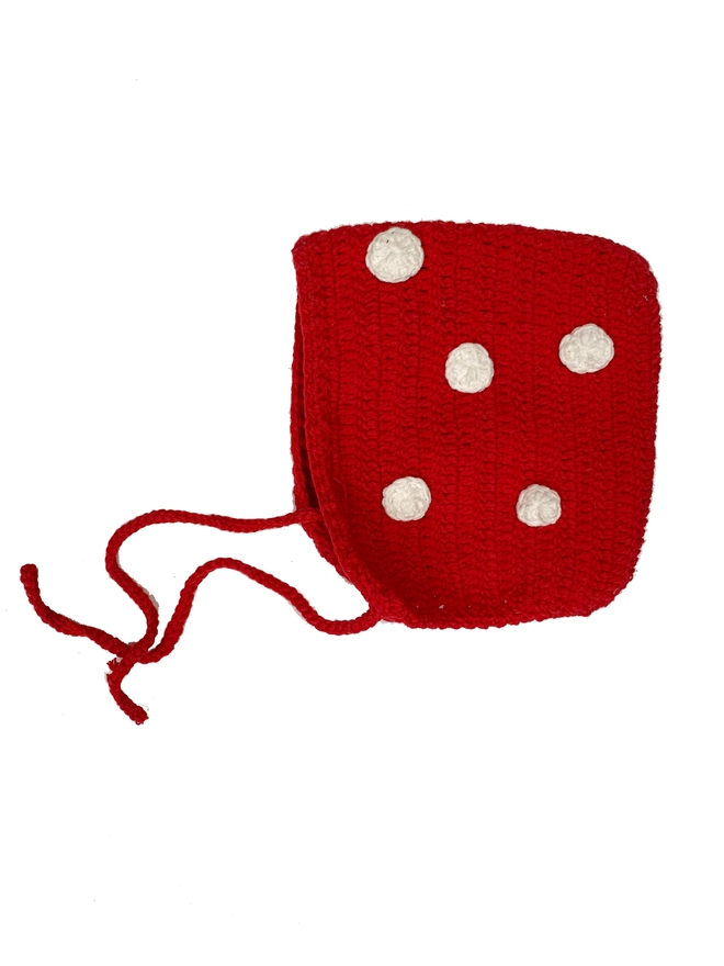 A red crocheted bonnet with white spots