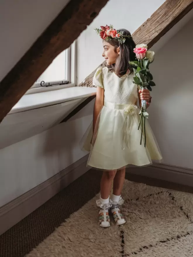 flower girl wearing a yellow dress and Pip and Henry blue metallic gladiator sandals