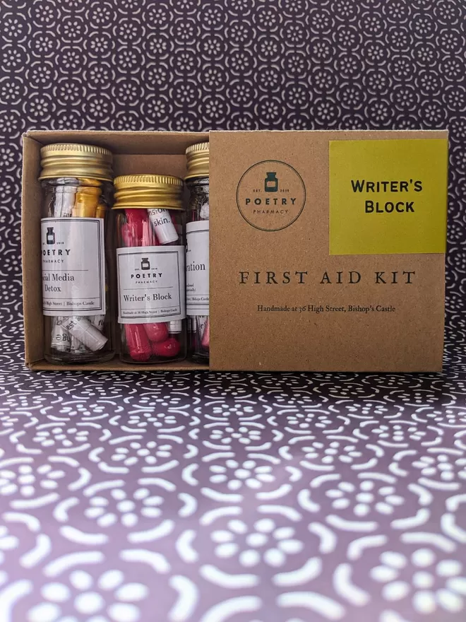 Open Cardboard box containing 3 glass bottles of poetry pills 