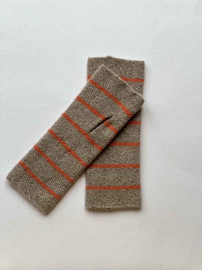 Knitted wristwarmers shown overlapping each other on a white background