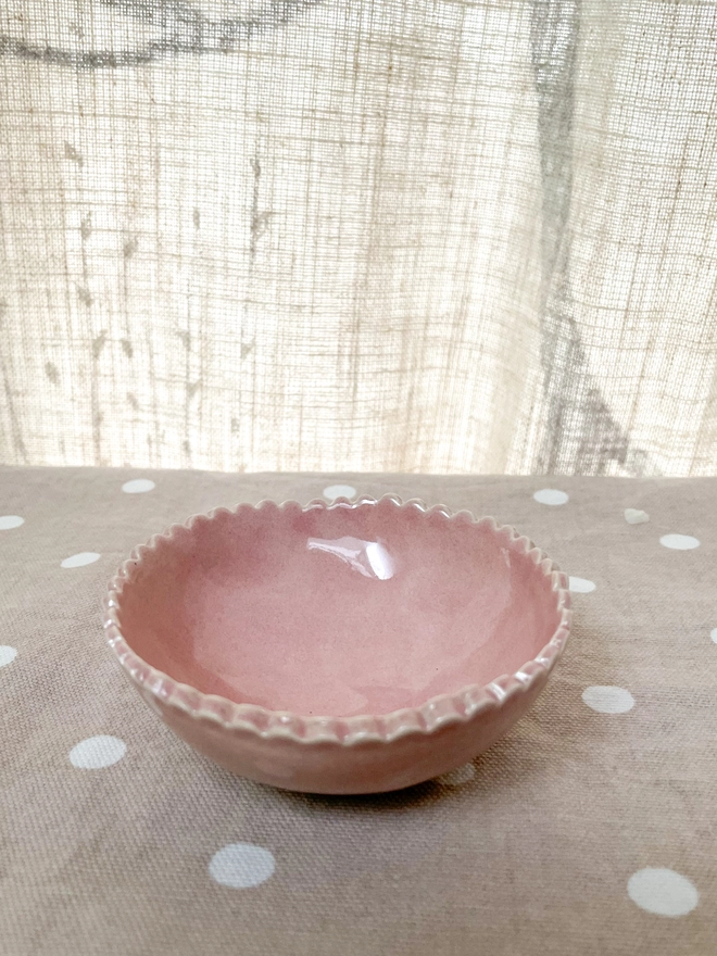 small pink handmade ceramic pottery bowl handmade with scalloped edge