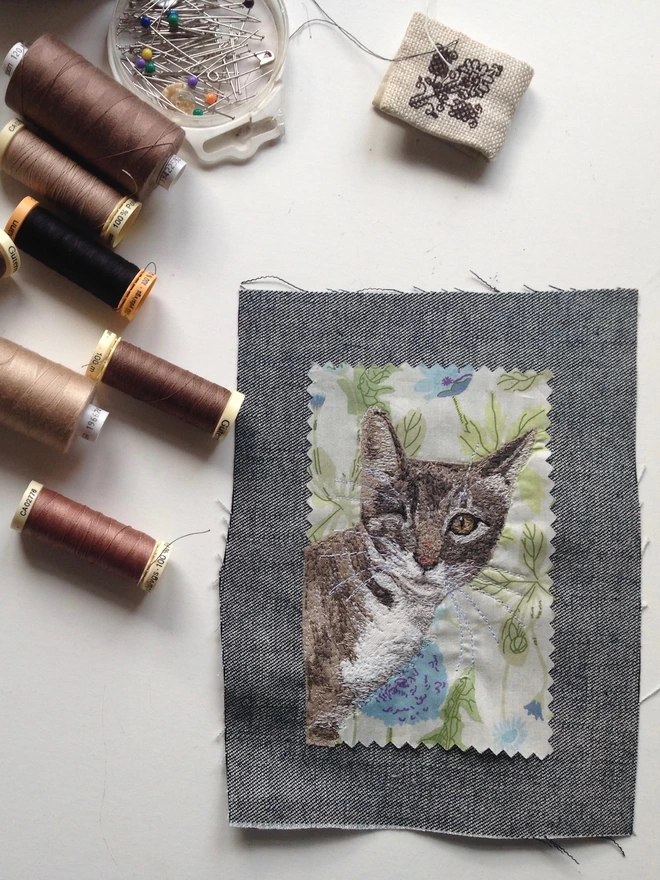 embroidered pet portrait of a cat on the sewing table