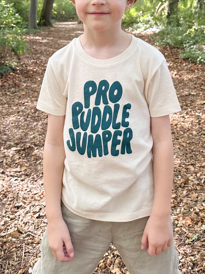 A young boy is wearing an organic cotton t-shirt with the words Pro Puddle Jumper