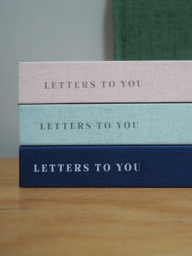 The notebooks stacked on top of each other with the words letters to you printed on the spine.