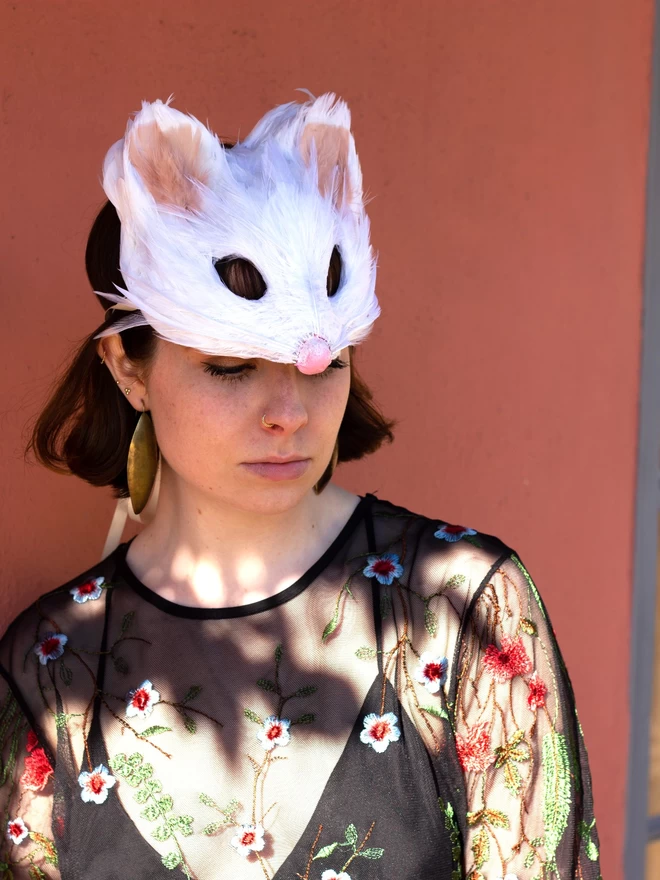 Woman wearing white mouse mask as a headdress