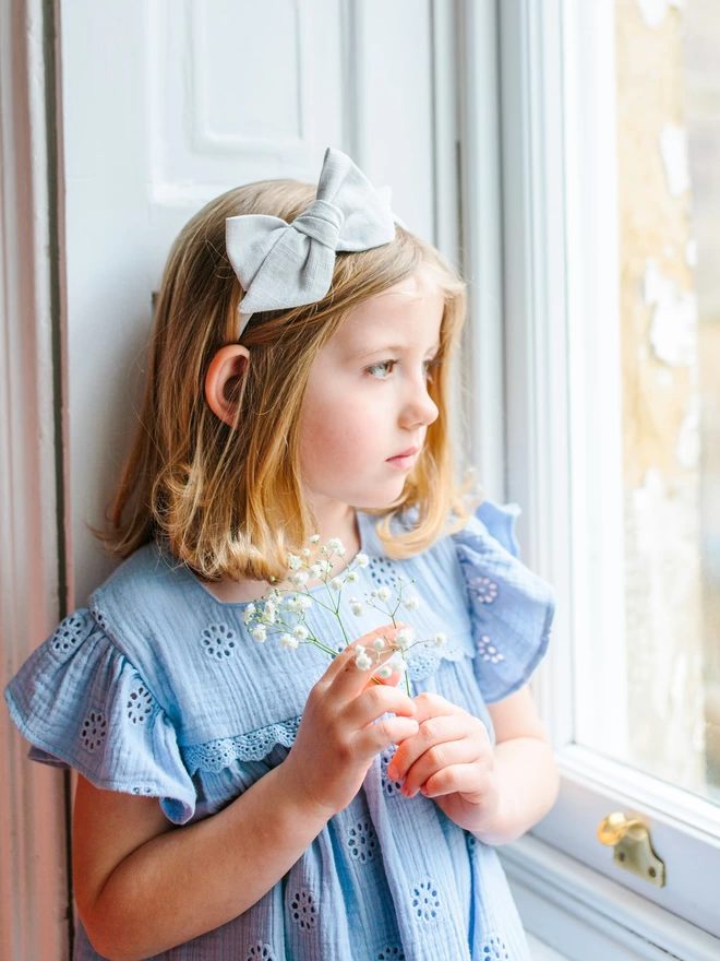 Girl with pale blue Alice band on looking out of the window