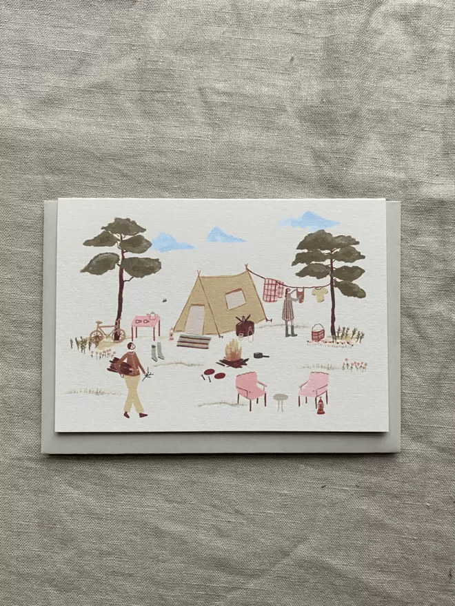 camping card with tent and 2 people around the campfire on it. 