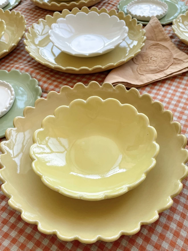 yellow scalloped edge pasta bowl with a yellow ice cram bowl stacked inside