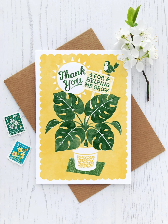 yellow and green teacher thank you card with brown envelope flowers and stamps