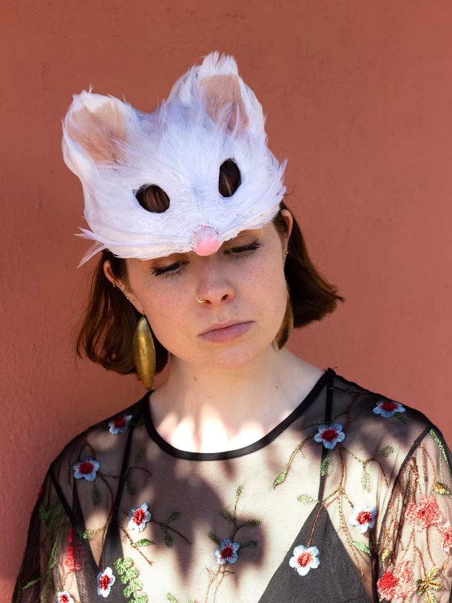 Woman wearing white mouse mask as a headdress