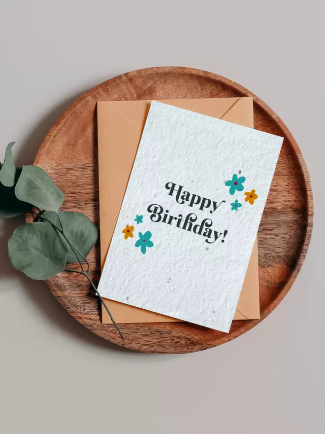 Happy Birthday Plantable Card Plantable Card with Floral Illustrations on a wooden tray next to eucalyptus
