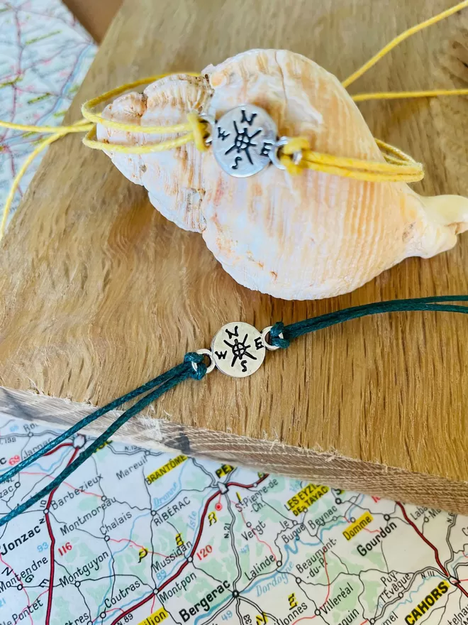 Close up of adventure wish bracelets with a compass charm.