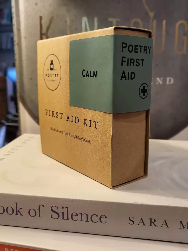Calm First Aid kit- cardboard box on pile of books