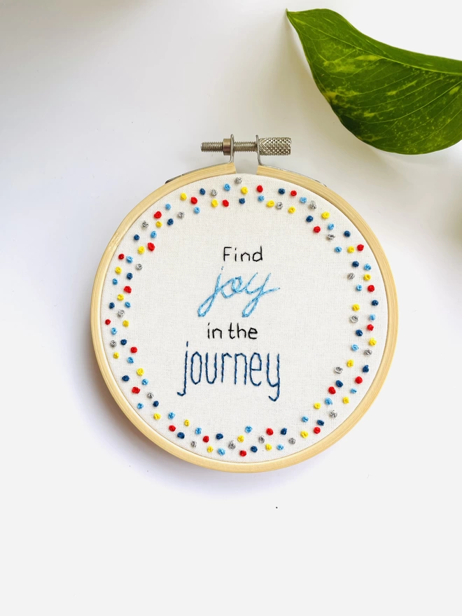 Hand embroidered hoop art reads find joy in the journey surrounded by colourful french knot border
