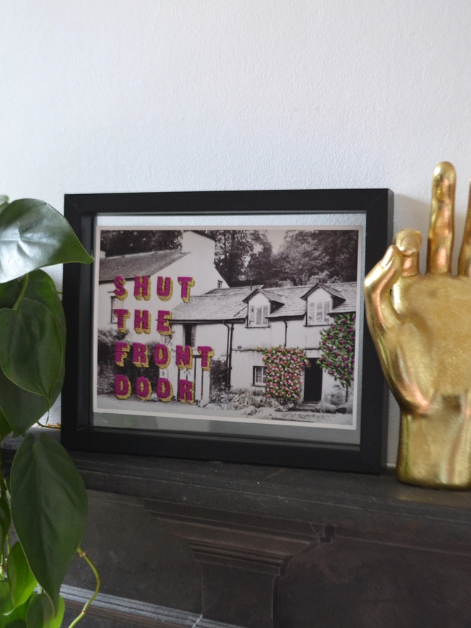 Print of Shut the front door embroidered on B&W cottage photo in frame