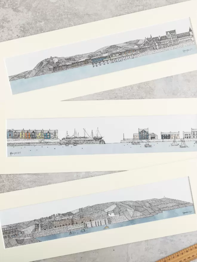 Print of detailed pen and watercolour drawings of seafronts at Aberystwyth, Aberaeron and Porthgain, in soft white mounts