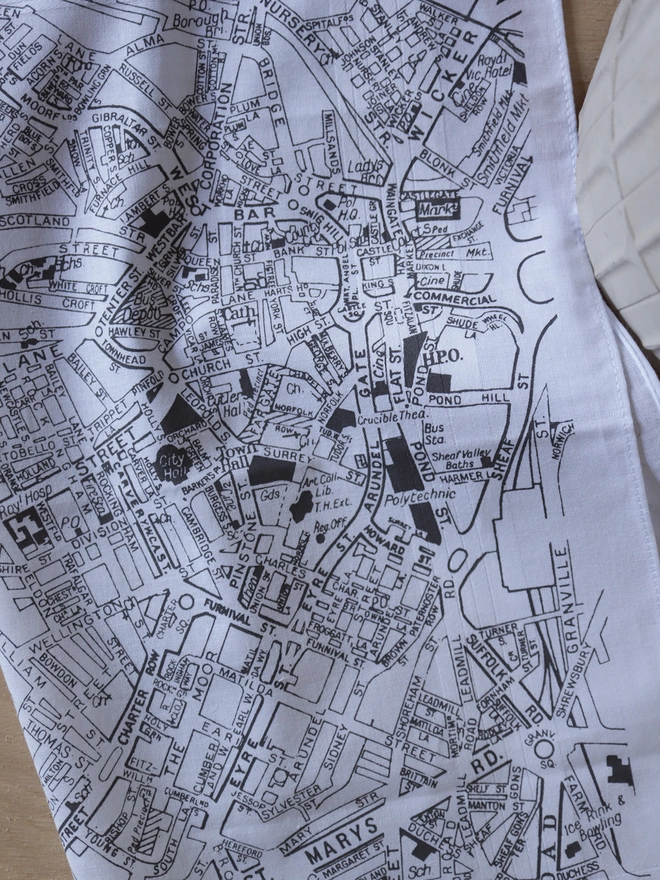 A lifestyle photo of a Mr.PS Sheffield Map hankie printed in grey with a concrete plant pot