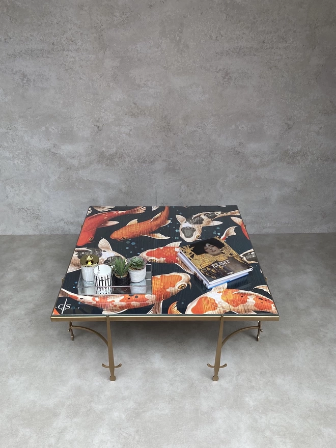 coffee table with glass artwork top of koi fish design