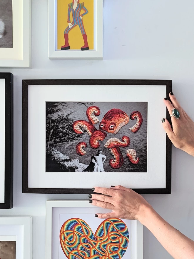 B & W photo of couple with embroidered octopus behind them, framed held on wall