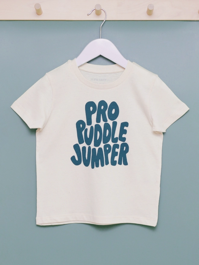 An organic cottong slogan t-shirt with the words Pro Puddle Jumper hanging from a hook