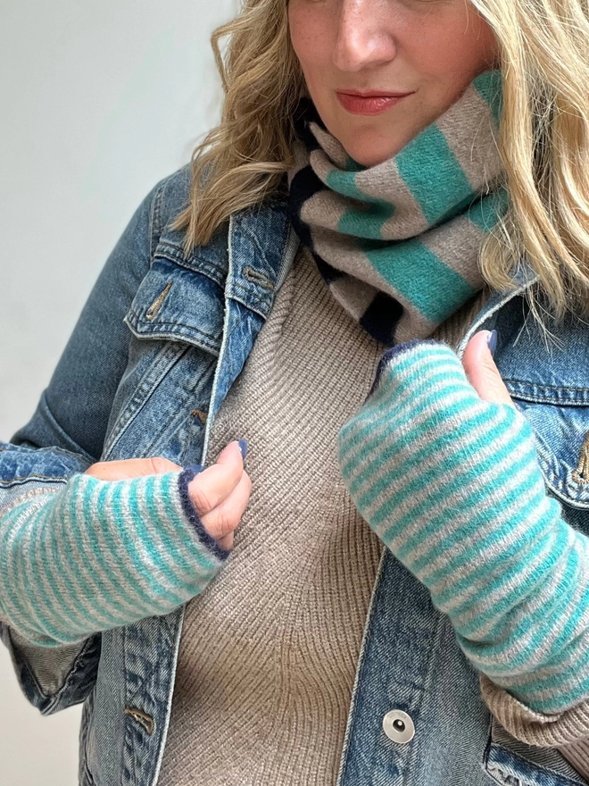 Knitted stripped wristwarmers being worn with matching snood