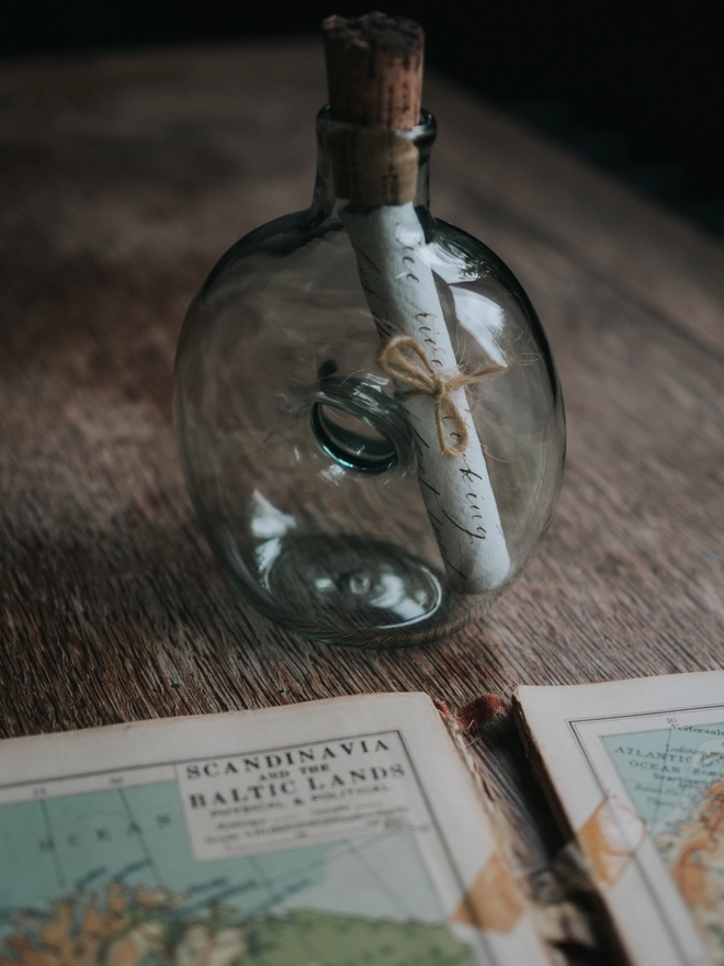 Map of Scandinavia and glass bottle with a message on a scroll inside it
