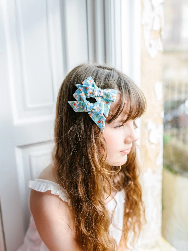 gIRL WITH HER LIBERTY HAIR BOWS IN BLUE