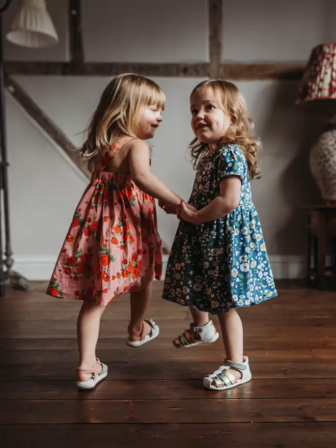 two little girls dancing wearing Pip and Henry blue metallic gladiator sandals