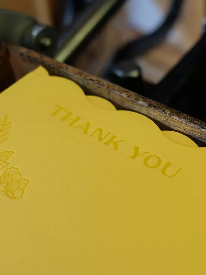 Wavy die-cut citrus yellow card with peony illustration and 'Thank you' debossed into the card. 