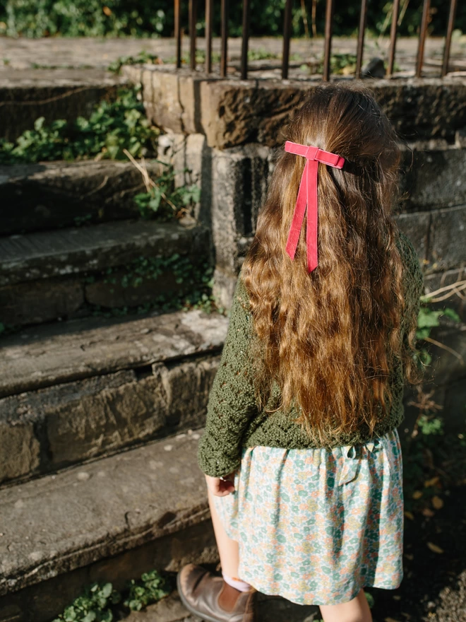 girl walking up steps in her velvet hair bow