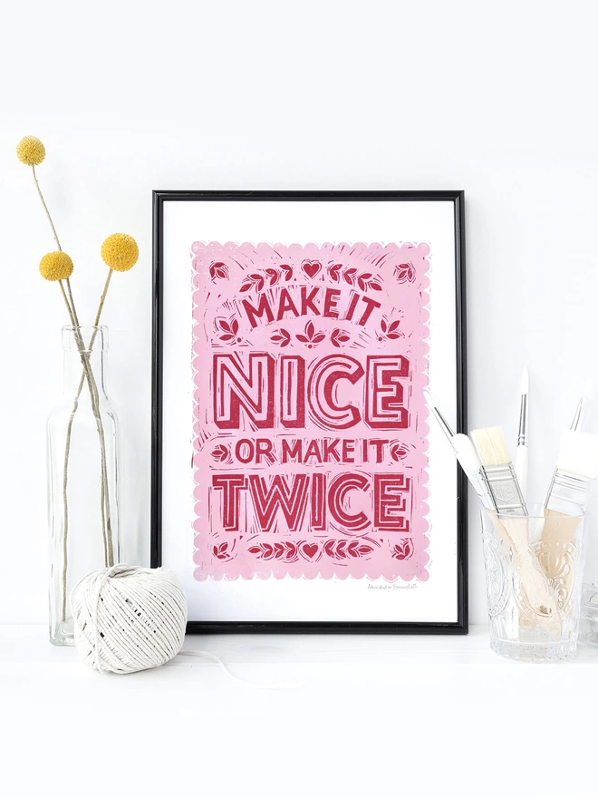 pink make it nice or make it twice print in black frame with string and flowers
