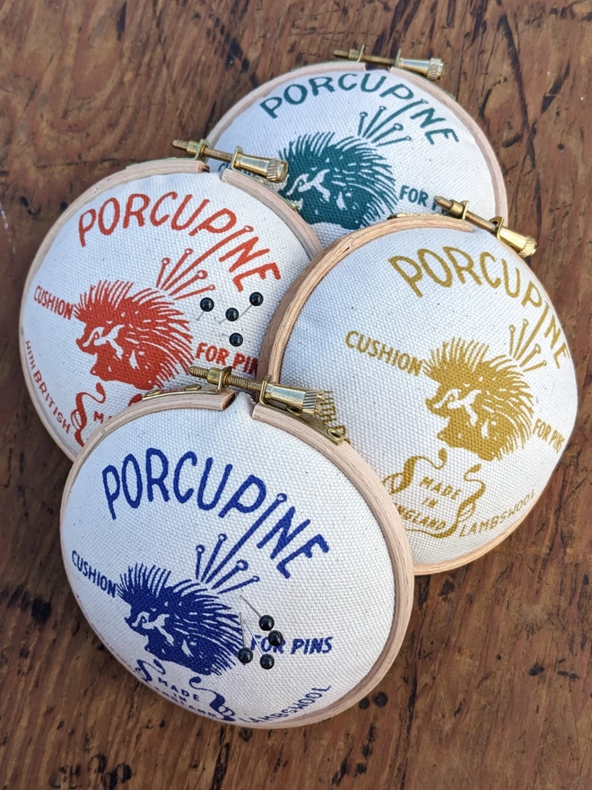 Four porcupine design embroidery hoop pin cushions in various colours