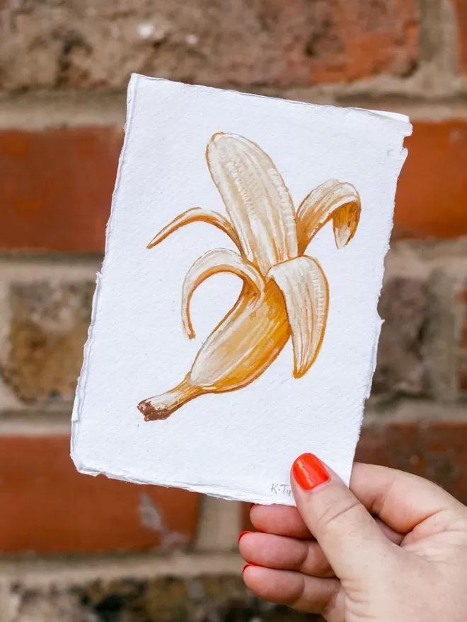 Katie Tinkler illustration of banana in front of a brick wall.
