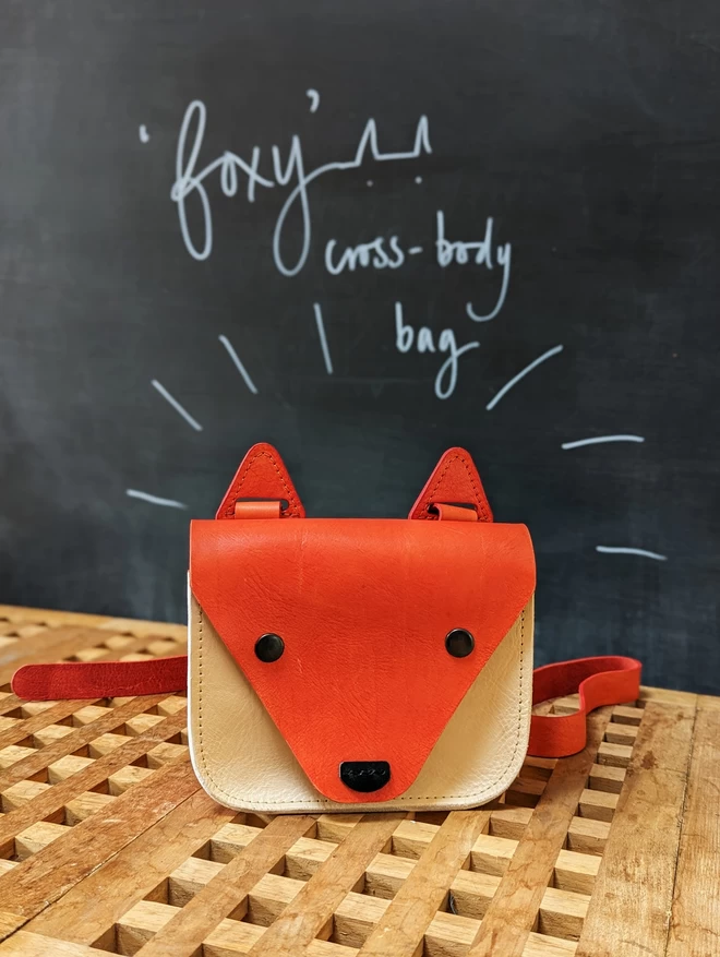  Handmade 'Foxy' cross- body handbag in hand- dyed orange and light tan leather.