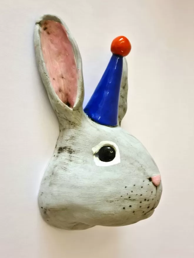 Bobby the rabbit trophy style head seen on a white wall from the side.