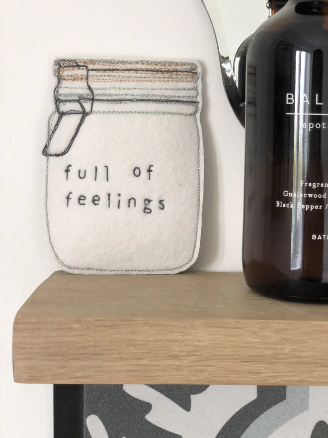 Jar Full of Feelings on bathroom shelf with bottle