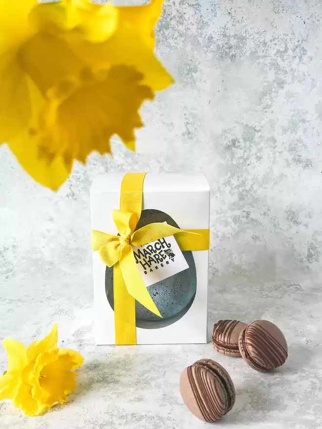 a gift box with chocolate egg and yellow daffodils