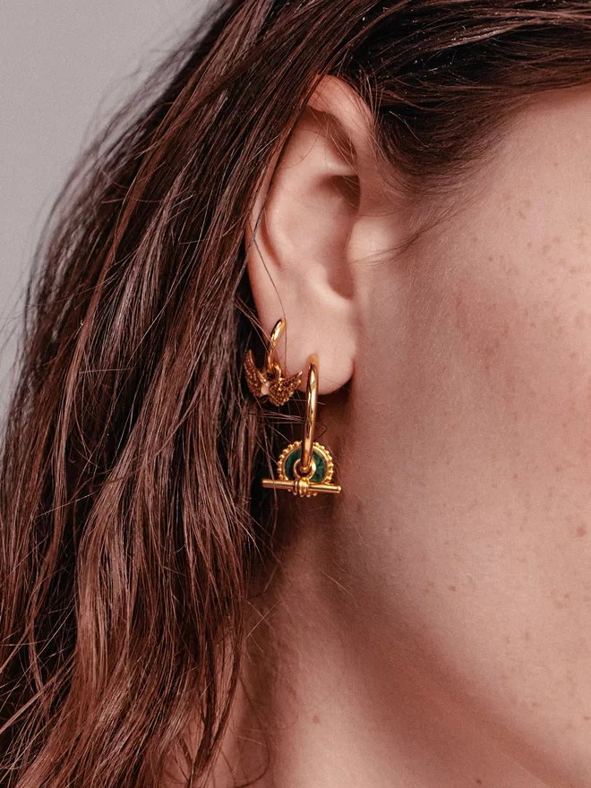 woman wearing gold earrings with charms